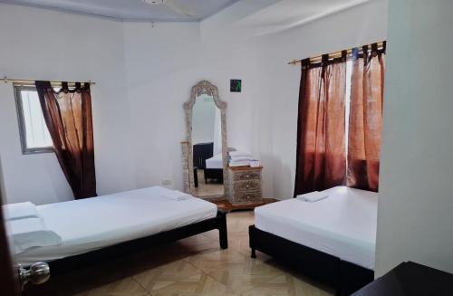 a bedroom with two beds and a mirror in it at Apt vacacional 301 in Doradal