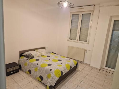 a bedroom with a bed with polka dots on it at Appartement 45m2 à Florange in Florange