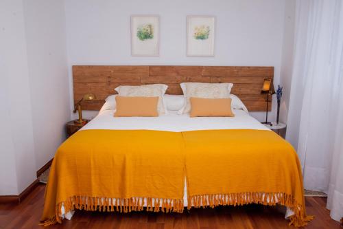a bedroom with a large bed with a yellow blanket at El Jardín de Wallada in Córdoba