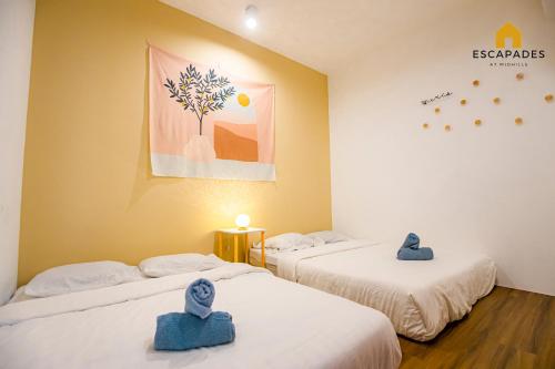 two beds in a room with blue towels on them at The Tropic@Midhill Genting (Free Wi-Fi) in Genting Highlands