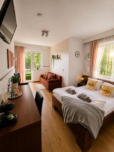 a bedroom with a large bed and a dining room at Safir przy samym WYCIĄGU in Karpacz