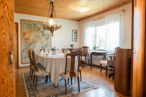 a dining room with a table and a painting on the wall at Kiulukka mökki in Jyväskylä