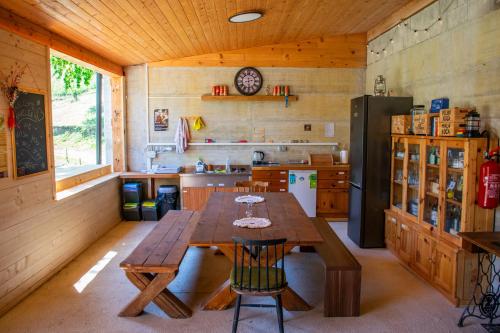 a kitchen with a wooden table and a refrigerator at Glamping Zeleni raj Vače in Vače