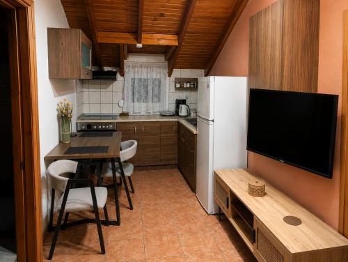 a small kitchen with a table and a white refrigerator at Noufara Apartments in Nea Mesangala