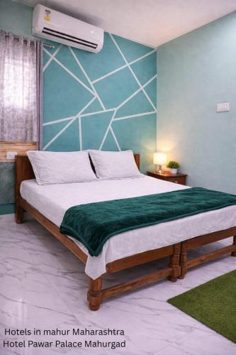 a bedroom with a bed with a green blanket at Hotel Pawar Palace Mahurgad in Māhūr
