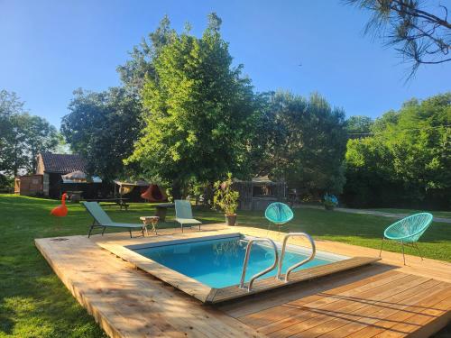 a swimming pool with two chairs and a table at Les Robinsonades in Couladère