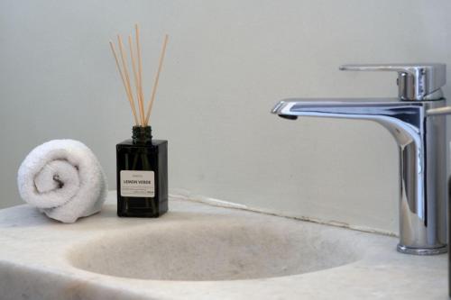 a bathroom sink with a bottle of soap and a towel at Moschoula Studios in Parikia