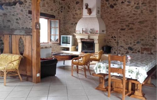a kitchen with a table and chairs and a fireplace at Ancienne Forge Avec Piscine in Saint-Mesmin