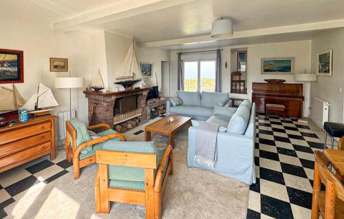 a living room with a blue couch and a fireplace at Maison Vue Mer in Quiberville