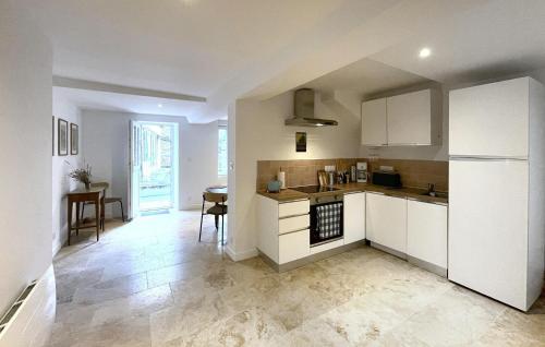 a kitchen with white cabinets and a table in it at Belle Maison À Colombages in La Baroche-sous-Lucé