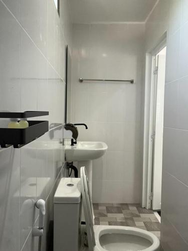 a white bathroom with a sink and a toilet at Koh Tao Townhouse in Ko Tao