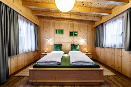 a bedroom with a bed in a wooden room at Ciasa Confolia in Corvara in Badia