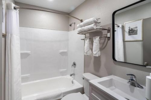 a white bathroom with a sink and a mirror at Super 8 by Wyndham Eureka in Eureka