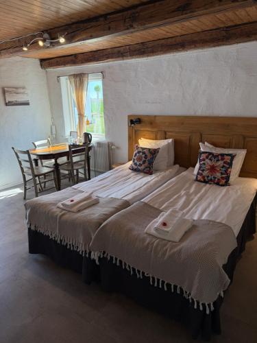 ein großes Bett in einem Zimmer mit einem Tisch in der Unterkunft Peppinge Bed & Breakfast in Löderup