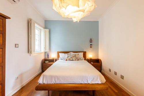 a bedroom with a bed and a chandelier at Casa do Rio in Chaves
