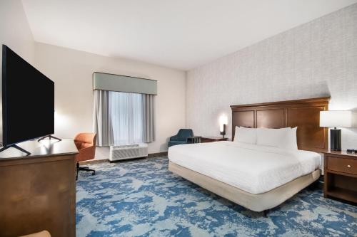 a hotel room with a bed and a flat screen tv at Hampton Inn Uvalde in Uvalde
