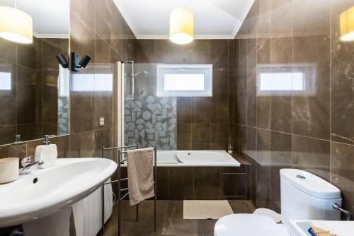 a bathroom with a sink and a toilet and a tub at Casa do Rio in Chaves
