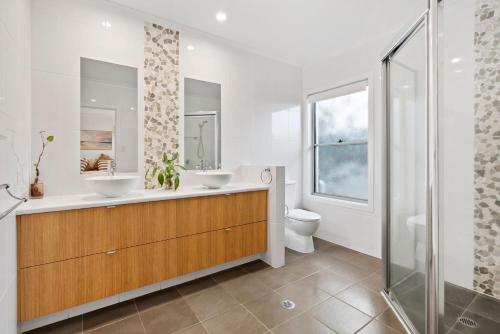 a bathroom with two sinks and a shower at Tallows Coastal Retreat in Kingscliff