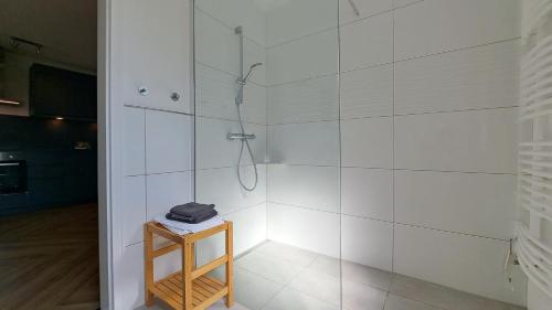 a bathroom with a shower and a wooden stool at Meerferienwohnungen Kühlungsborn in Kühlungsborn