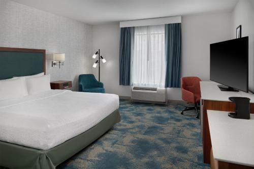 a hotel room with a bed and a desk and a tv at Hampton Inn & Suites Detroit/Troy in Clawson