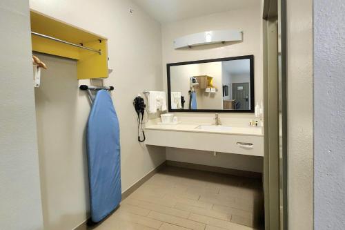 a bathroom with a sink and a large mirror at Days Inn & Suites by Wyndham Katy in Katy