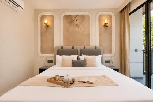 a bedroom with a large white bed with two windows at Alaya Stays Luxora Suites, Golf Course Rd near galleria in Gurgaon