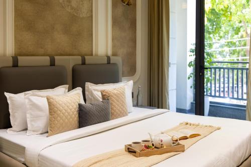 a large white bed with a tray on it at Alaya Stays Luxora Suites, Golf Course Rd near galleria in Gurgaon