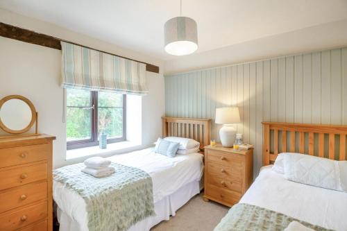 a bedroom with two beds and a window at 2 Bed in Carmel oc-wai210 in Llanerchymedd