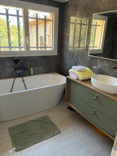 a bathroom with a white tub and a sink at Villa Naussica in Saint-Raphaël