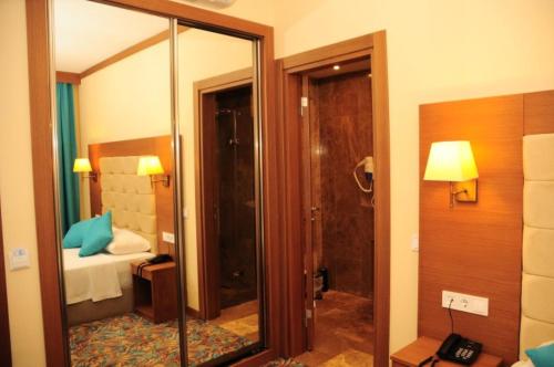 a hotel room with a shower and a bedroom at Liona Hotel & SPA in Gundogan