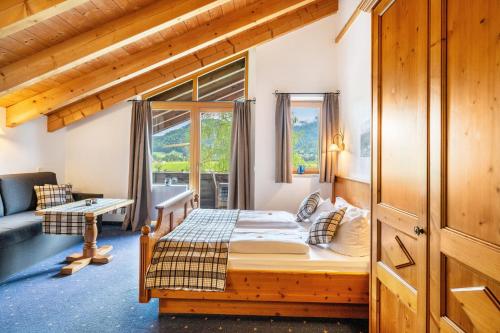 a bedroom with a bed and a large window at Gästehaus Tanneck mit Hallenbad in Reit im Winkl
