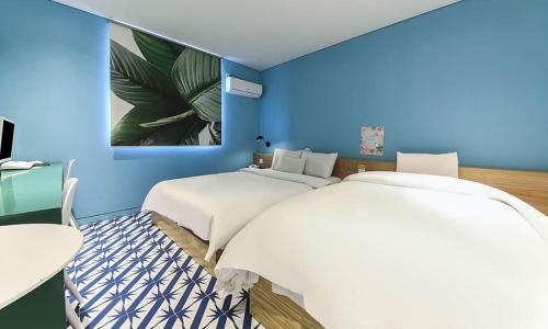two beds in a room with blue walls at Hotel Yeogiuhtte Chungjangro in Gwangju