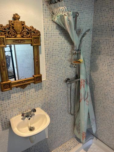 a bathroom with a sink and a shower curtain at Maison SItta in Montferrier