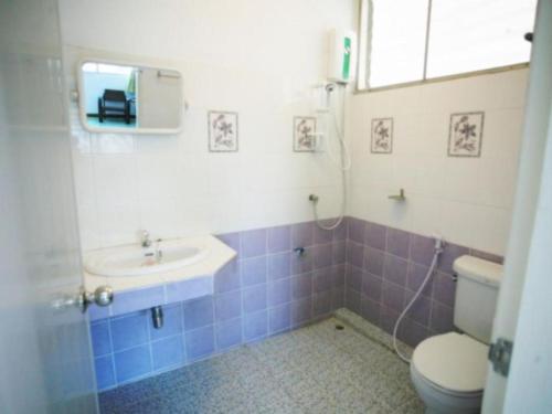 a bathroom with a toilet and a sink at Miami Hotel in Chiang Mai