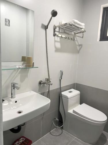 a white bathroom with a toilet and a sink at Hải An Hotel in Nhượng Bạn
