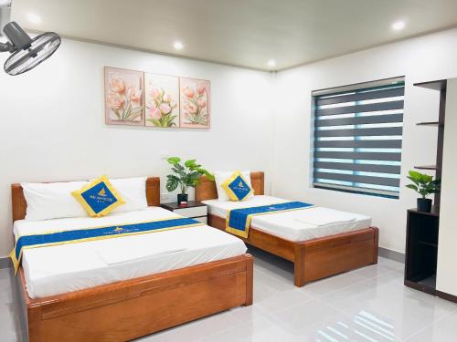 a bedroom with two beds and a window at Hải An Hotel in Nhượng Bạn