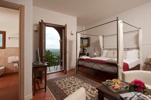 a hotel room with a bed and a balcony at Saturnia Tuscany Hotel in Saturnia