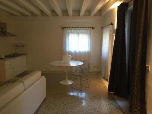 a living room with a table and a white table at Ca' Bert Villa dei Glicini B&B in Castelnuovo del Garda