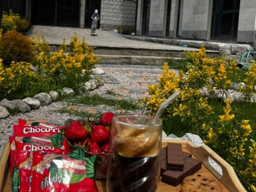 a table with a drink and strawberries on it at Bee Planet Garni in Garni