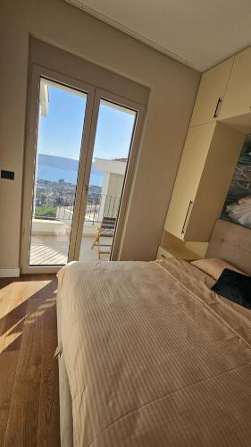 a bedroom with a large bed and a large window at Damisa Lux Stan in Tivat