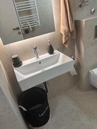 a bathroom with a white sink and a mirror at Damisa Lux Stan in Tivat