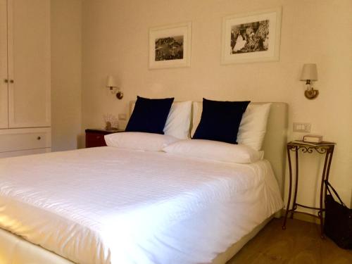 a bedroom with a large white bed with blue pillows at Solarium Achilles in Giardini Naxos
