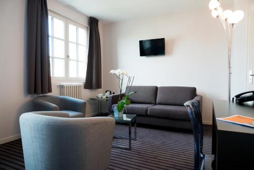 a living room with a couch and a table at Le Germinal in Cesson-Sévigné