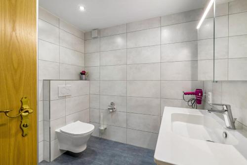 a white bathroom with a toilet and a sink at Leicht in Münsingen