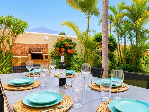 a table with a bottle of wine and glasses at Humboldt Garden in La Orotava