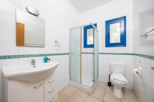 a white bathroom with a sink and a toilet at Azzurro Holiday Villas in Peyia