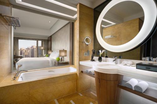 a bathroom with a tub and a large mirror at Kempinski Hotel Chongqing in Chongqing