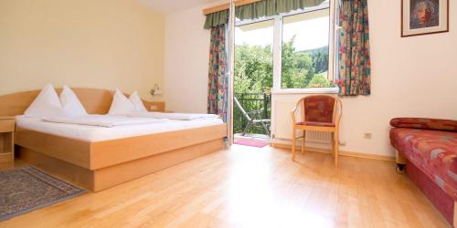 a bedroom with a bed and a window and a couch at Flackl - Wirt in Reichenau