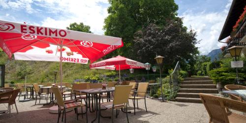 an outdoor restaurant with tables and chairs and an umbrella at Flackl - Wirt in Reichenau