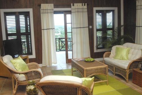 a living room with a couch and chairs and a tv at Heavenly Suites in La Feuillet